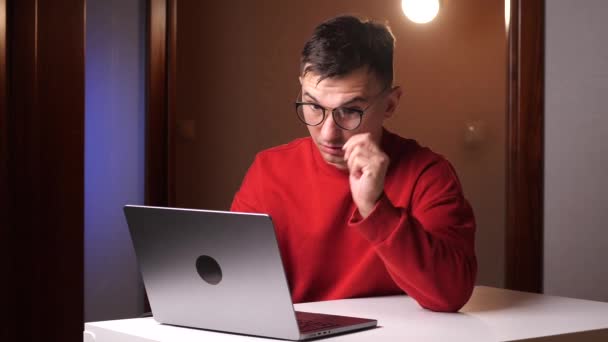 Homem Usando Óculos Uma Camisola Vermelha Trabalha Casa Laptop Fadiga — Vídeo de Stock