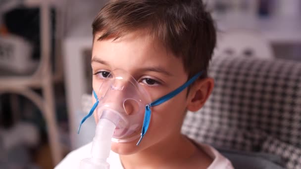 気管支炎 インフルエンザ ネブラライザー 吸入器 蒸気でマスクを使用して咳の治療を受けている少年のクローズアップ 子供のための家庭治療 蒸気の形をした薬 — ストック動画