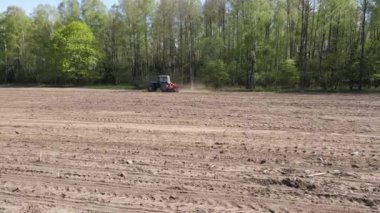 Doğu Avrupa 'daki eski mavi traktörün hava manzarası Ukrayna Belarus mısır tarlası ekiyor. Bahar tarlası ekildi. Eski mavi traktör ormanın yakınına bir tarla eker.
