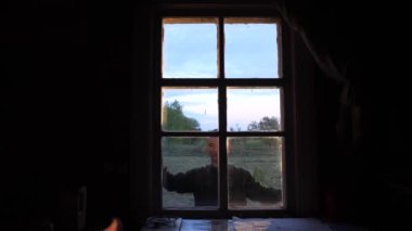 Eski bir kırsal evin dışındaki eski ahşap panjurları açan bir adamın yakın çekimi. Selamlama jesti. El sallıyorum. Başlangıç konsepti, başla. Mavi ahşap panjurlar. Pencereden evin içine bak..
