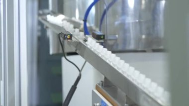 Küçük beyaz plastik parçaların endüstriyel üretimi. Plastik parçalar üretim hattı. Küçük parçalar otomatik makine tarafından üretilir