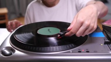 Kız vinil plağa pikap iğnesi koyuyor. Eski bir plakçaları açan bir kadının el çekimi. Anne ve kızı klasik bir plakta birlikte müzik dinlerler.