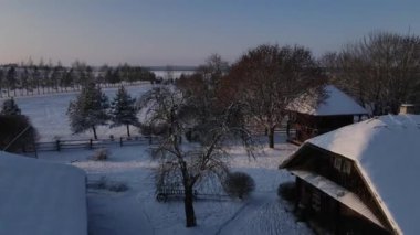 Eski bir Doğu Avrupa köyünde kışın şafak sökerken. Belarus 'ta bir köyde eski ahşap evler. İHA 'dan, havadan, üstten.
