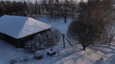 Hava görüntüsü. Vinç. Köy evinin yakınındaki eski kuyu. Beyaz Rusya ve Ukrayna için tipik bir durum. Kış sabahı köy evinde. İHA ile vurulmuş.