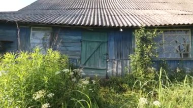 Terk edilmiş eski bir ahşap çiftlik evi çürüyor ve dökülüyor, çalılar ve otlarla kaplanıyor. Terk edilmiş bir evde asma kilitli bir kapı. Ön kapı kilitli..