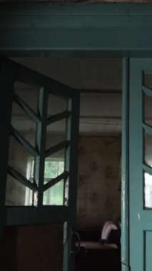 Dikey video Zavallı Adam kulübesi. Radyoaktif serpinti. Terk edilmiş bir ev. Terk edilmiş eski bir evde bir oda. Terk edilmiş eski bir ahşap evde iç kapılar.