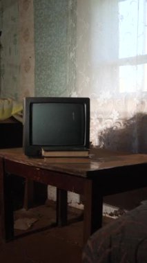 Terk edilmiş bir evde dikey video televizyon. Terk edilmiş tozlu bir odada eski bir televizyon. Tozlu TV 'yi kapat. Radyoaktif serpinti