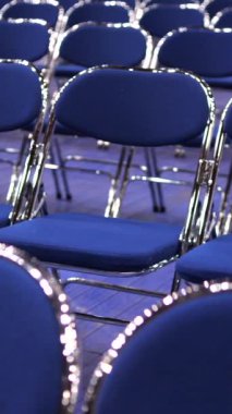 Seminerden, konserden, ön seçimlerden, tartışmalardan önce boş bir oditoryum. Seyircisi olmayan boş mavi sandalyeler. Geçici seyirci koltukları. Metal katlanır sandalyeler