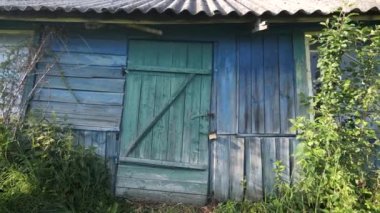 Eski ev asma kilitli. Ön kapı kilitli. Köyde terk edilmiş ahşap bir evin asma kilitli kapısı. Kamera hareket ediyor, kamera yaklaşıyor.. 