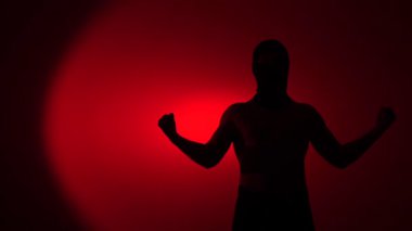 Sokak dövüşçüsü, Anonim Siluet Adam dövüşçüsü kırmızı arka planda duruyor, iki kolunu da sıkmış, güçlü ve kararlı bir duruş sergiliyor ve protesto ediyor.