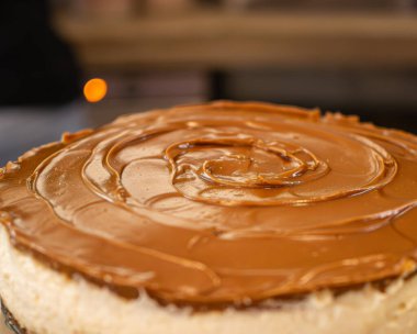 Ön planda kremalı karamel keki, profesyonel bir kahve dükkanında, el yapımı bitkisel malzemelerle..