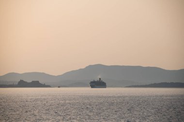 Gün batımında denizin ortasında bir yolcu gemisi.