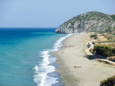 Arka planda dağ olan bir sahil.