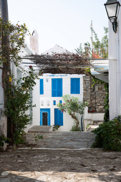 a narrow alley with a blue door and a white building