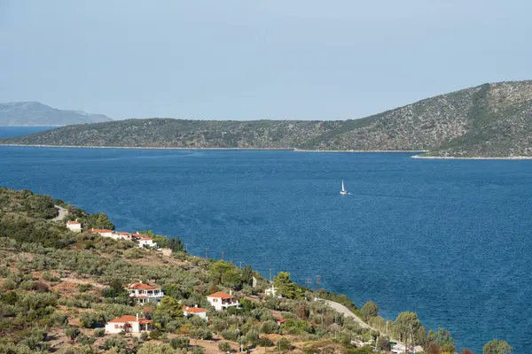 Küçük bir kasabanın yakınında okyanusta seyreden bir tekne.