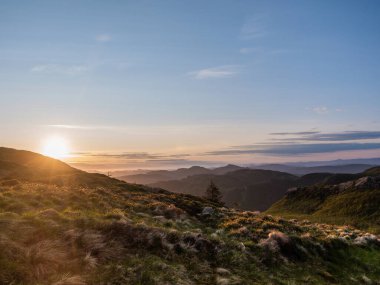 Soğuk bahar gecesi Alpenglow gökyüzü ile Vidden patikasında yürüyüş, 24 saatlik günbatımı periyodunda Norveç 'te Rundemanen Dağı' ndan