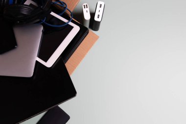 Eski dizüstü bilgisayarlarla, dijital tabletlerle, akıllı telefonlarla dolu karton kutu gri arka planda geri dönüşüm için elektrik bankası. Bağış, e-atık, yeniden kullanım, yenilenme ve geri dönüşüm konsepti için elektronik atık
