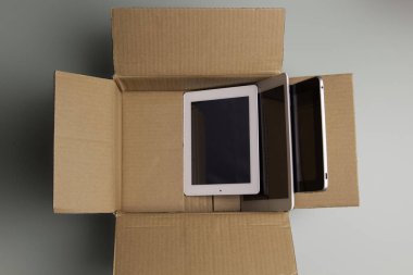 Eski bilgisayarları bağışlamak ve elektronik aletleri hayır kurumlarına bağışlamak. Karton kutuda toplanmış eski dijital tablet bilgisayarlar. Bağış teknolojisi, e-atık, yeniden kullanım, yenilenme ve geri dönüşüm konsepti için elektronik atık.