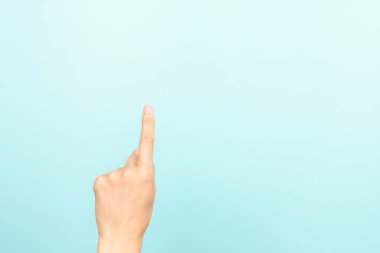 El hareketlerini göster, dokun, indekse bas, bir şey seç. Açık mavi arka planda işaret parmağı olan bir kadın. Kadın eli bir numarayı gösteriyor. Ön görünüm.