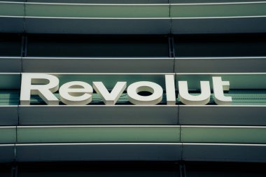 Revolut company logo signboard on modern office building in Vilnius, Lithuania on November 09, 2022. Revolut is British financial technology company that offers banking services. clipart