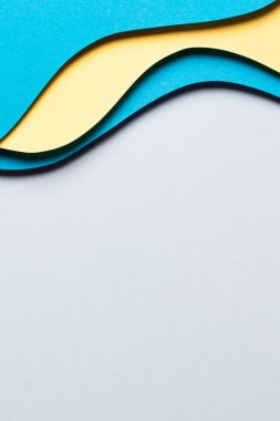 Soyut renkli kağıt dokusu arkaplanı. Minimum kağıt, geometrik şekil katmanları ve açık mavi ve sarı çizgilerle kompozisyonu keser. Üst görünüm.