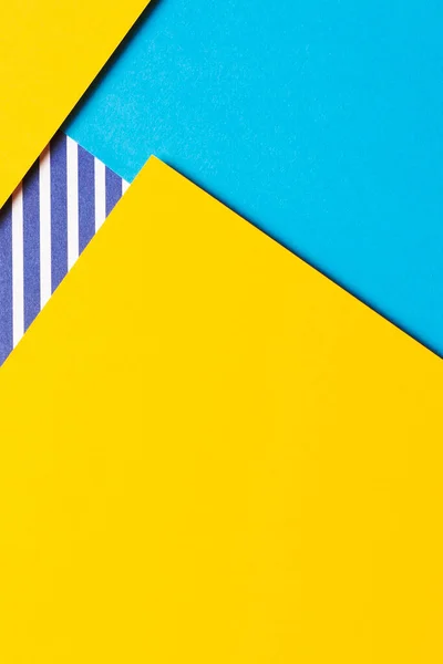stock image Abstract geometric fashion colored papers texture background. Yellow, light blue and striped white and blue color paper background. Top view, flat lay.