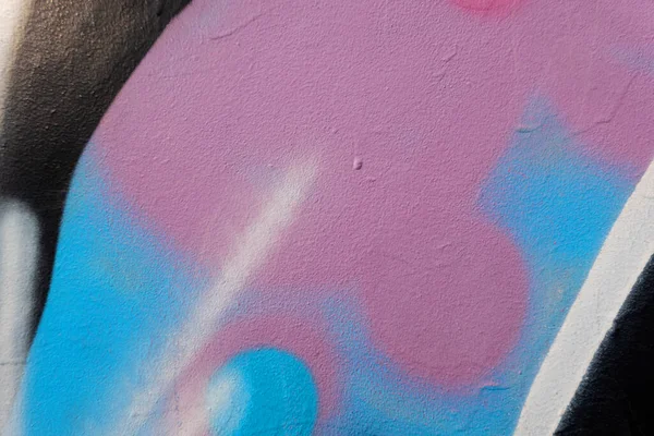 落書きの絵と古い石膏の壁の断片 壁の背景にカラフルなストリートアートの落書きの一部 都市文化 パステルピンク ライトブルー ブラック ホワイト — ストック写真