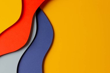 Soyut renkli kağıt dokusu arkaplanı. Asgari kağıt, geometrik şekil katmanları ve kırmızı, sarı ve mavi renkli çizgilerle stil kompozisyonu keser. Üst görünüm.