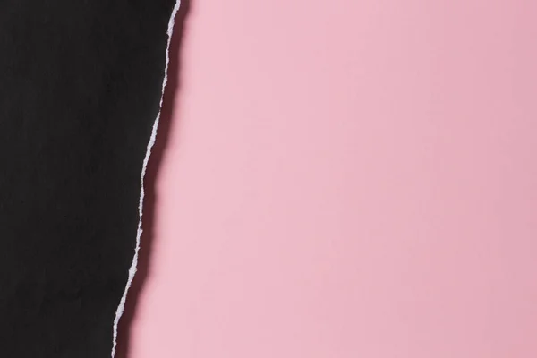 黑色的发牢骚撕破的纸片 边缘破布在粉红的彩色纸背景上 顶部视图 复制空间 — 图库照片