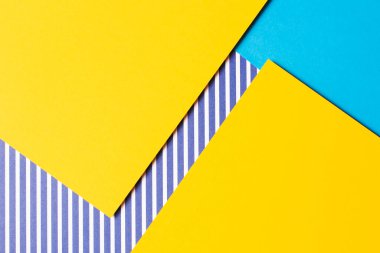 Soyut geometrik moda renkli kağıt doku arka planı. Sarı, açık mavi ve çizgili beyaz ve mavi renkli kağıt arka plan. Üst manzara, düz uzanma.
