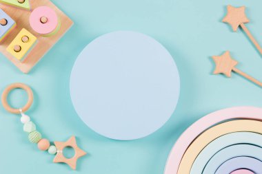 Boş platform kürsüsü ve açık mavi arka planda doğal ahşap ekolojik sürdürülebilir sıfır atık eğitim oyuncakları. Montessori, çocuklar için çevre dostu oyuncaklar. Üst manzara, düz uzanma.