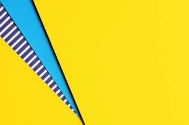 Soyut geometrik parlak renkli kağıtların doku arka planı. Sarı arka plan ve mavi, arasında mavi ve beyaz çizgiler olan çizgili kağıt. Üst manzara, düz uzanma.
