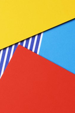 Soyut geometrik moda renkli kağıt doku arka planı. Sarı, kırmızı, mavi ve çizgili kağıt arka plan. Üst manzara, düz uzanma.