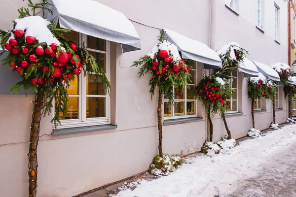 Noel 'e kadar süslemeler, süslemeler ve çelenk ışıklarıyla süslenmiş bir bina. Şehir caddesinde modern Noel dekorasyonu. Avrupa 'da kış tatili.