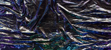 Siyah renkli plastik ambalaj arka planı. Koyu buruşuk plastik bir selofan. Renkli yanardöner ışığı yansıtıyor ve plastik yüzeydeki kıvrımlar ve kıvrımlar üzerinde gölge oluşturuyor. Doku kaplama efekti şablonu