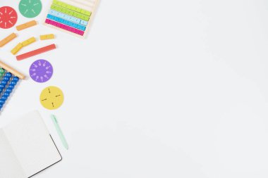 Matematik, beyaz arka plandaki kaynakları öğreniyor. Erken matematik becerileri. Renkli abaküs, matematik kesirleri, beyaz masadaki kağıt defteri ve kalemi aç. Üst manzara, düz uzanma.