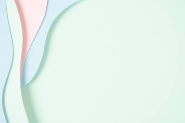 Soyut renkli kağıt dokusu arkaplanı. Minimum kağıt geometrik şekil katmanlarıyla kompozisyonu kesiyor ve pastel yeşil, pembe ve açık mavi renkte çizgiler çiziyor. Üst görünüm, alanı kopyala.