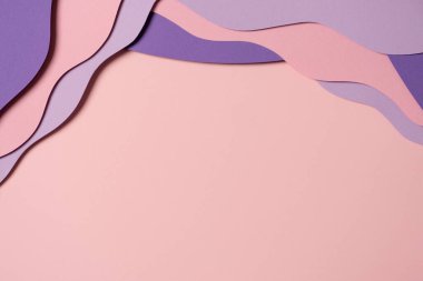 Abstract colored paper texture background. Minimal paper cut composition with layers of geometric shapes and lines in pastel pink and violet purple colors. Top view, copy space.