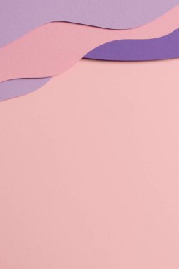 Abstract colored paper texture background. Minimal paper cut composition with layers of geometric shapes and lines in pastel pink and violet purple colors. Top view, copy space.