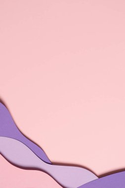 Abstract colored paper texture background. Minimal paper cut composition with layers of geometric shapes and lines in pastel pink and violet purple colors. Top view, copy space.