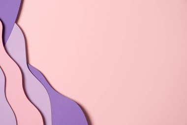 Abstract colored paper texture background. Minimal paper cut composition with layers of geometric shapes and lines in pastel pink and violet purple colors. Top view, copy space.