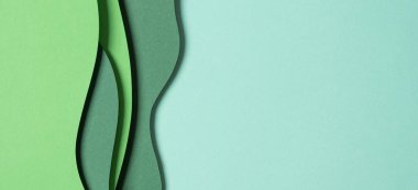 Abstract green color paper texture background. Minimal paper cut style composition with layers of geometric shapes and lines in green tone shades. Top view.
