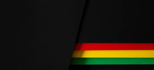 Black History Month color background. African American history month celebration. Abstract red, yellow, green color flag on black paper background.