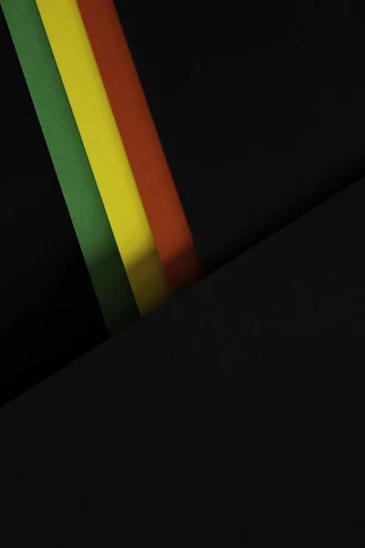 Black History Month color background. African American history month celebration. Abstract red, yellow, green color flag on black paper background.