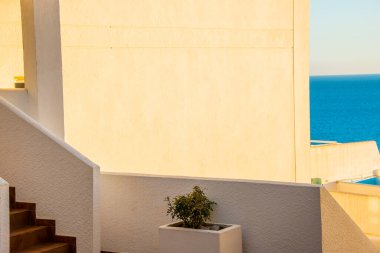 Architectural detail of white mediterranean house by the sea in sunny day. Minimal architecture building detail in Spanish coastline by Mediterranean sea in Spain.