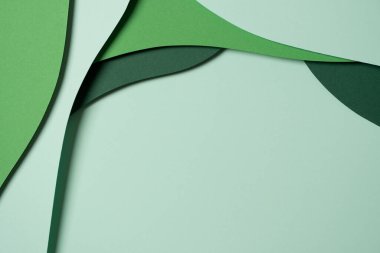 Abstract green color paper texture background. Minimal paper cut style composition with layers of geometric shapes and lines in green tone shades. Top view.