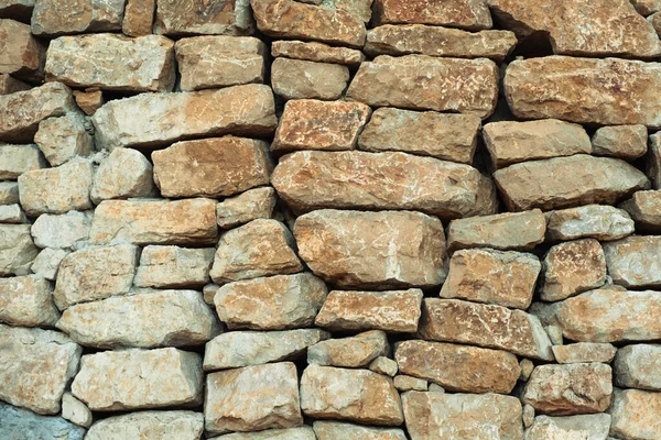 Masonry wall of stones with irregular pattern texture background.