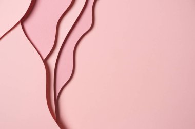 Abstract colored paper texture background. Minimal paper cut composition with layers of geometric shapes and lines in pastel pink colors. Top view, copy space.