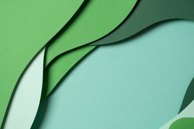 Abstract green color paper texture background. Minimal paper cut style composition with layers of geometric shapes and lines in green tone shades. Top view.