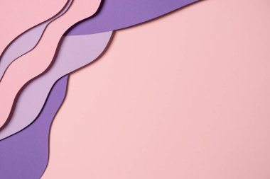 Abstract colored paper texture background. Minimal paper cut composition with layers of geometric shapes and lines in pastel pink and violet purple colors. Top view, copy space.